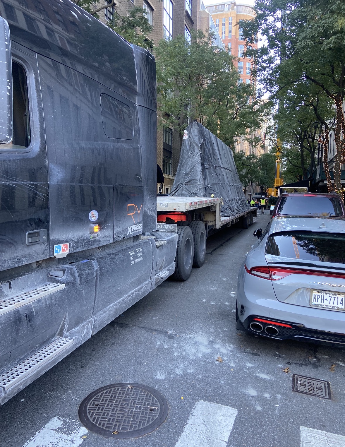 Dark RY truck with tarped flatbed load in New York City