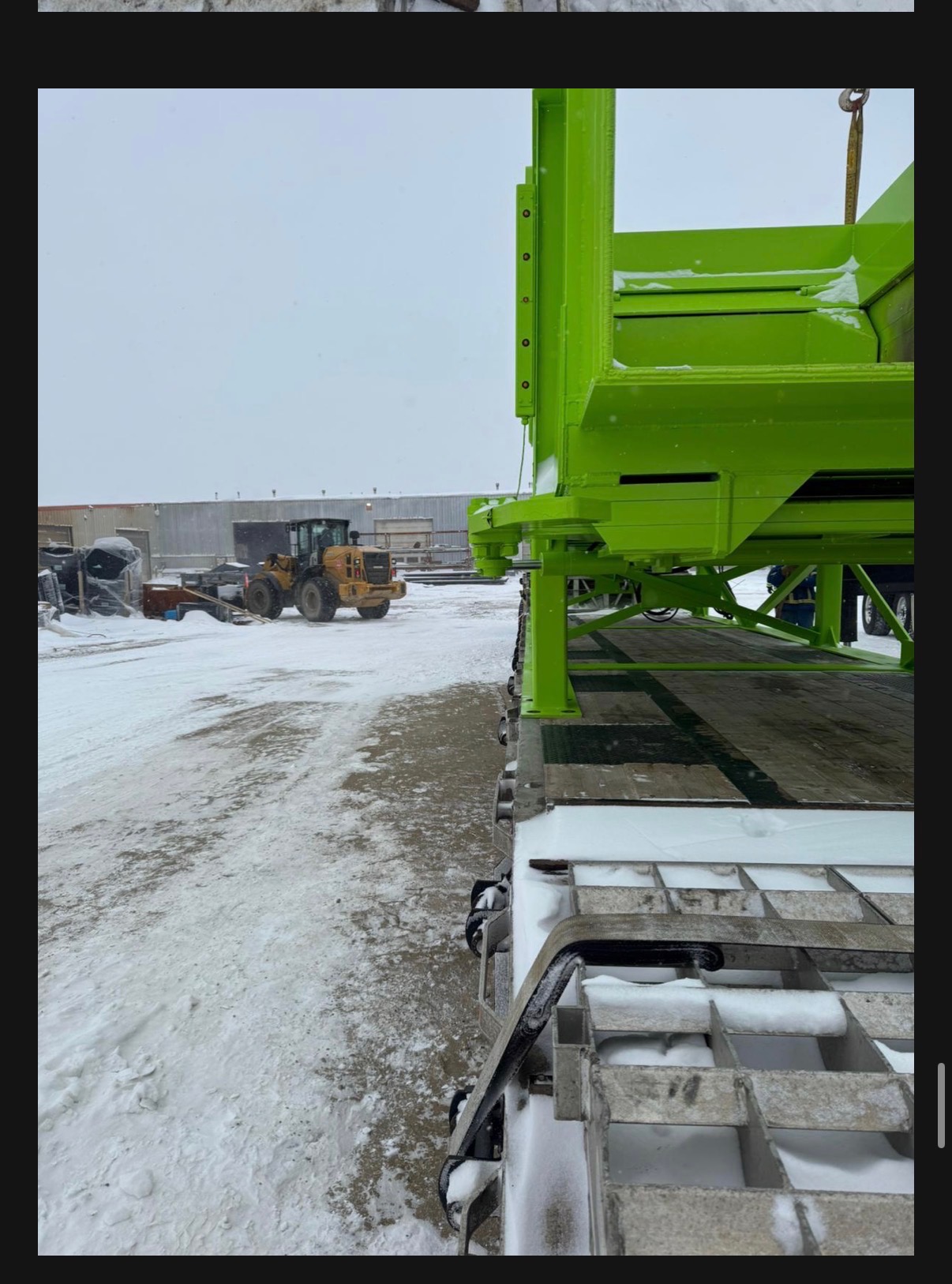 Close-up of green industrial hopper being loaded at facility