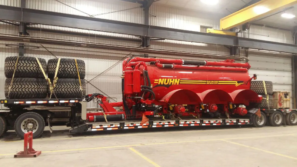 Red NUHN tank equipment on flatbed trailer in warehouse