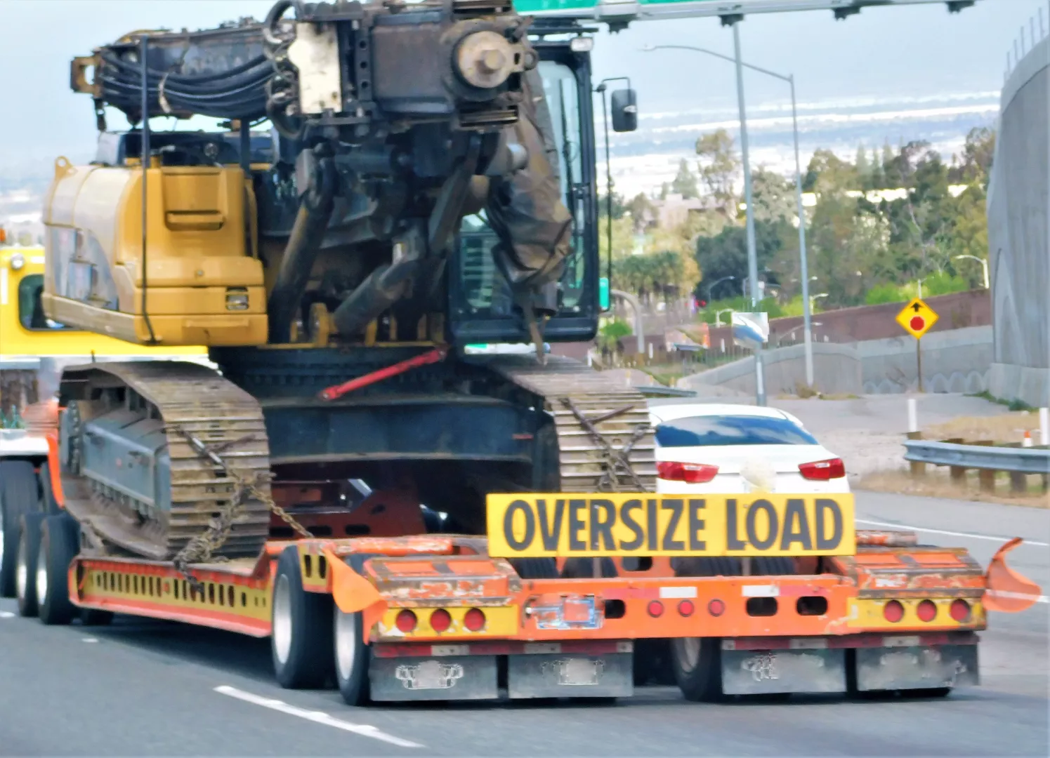 Oversize load - excavator on lowboy trailer on highway