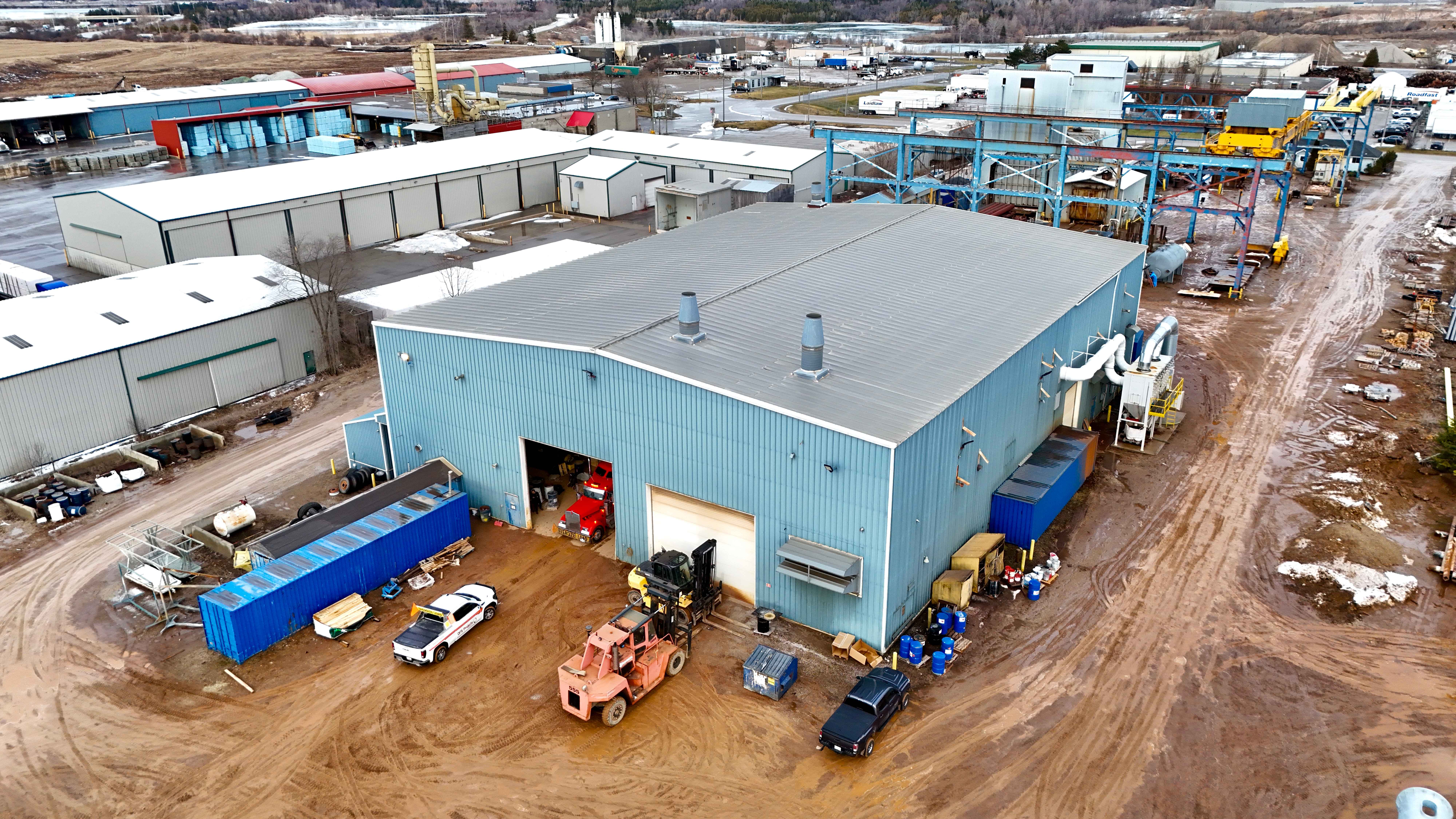 Aerial drone shot of blue industrial warehouse facility